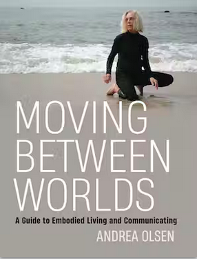 Book cover of Andrea Olsen's new book - with white lettering a photo of Andrea kneeling on a beach in a black wetsuit.