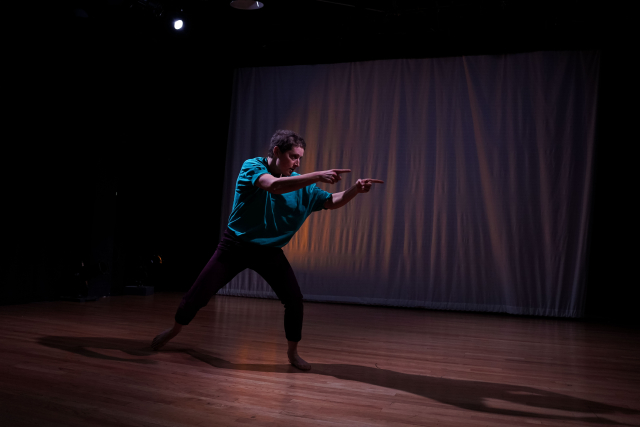 A solo dancer lunges left and points left.