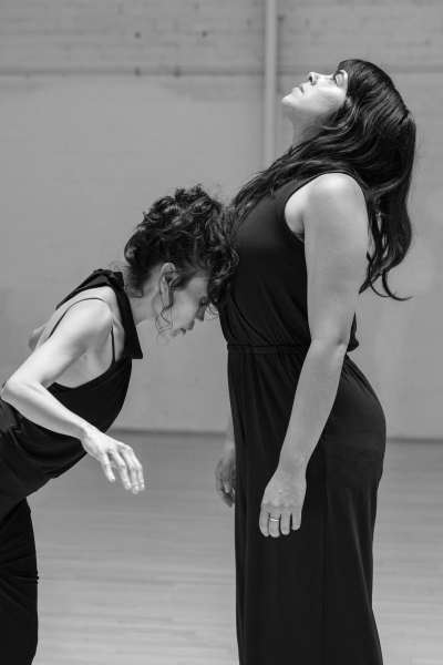 One dancer leans her head on the other dancer's sternum.